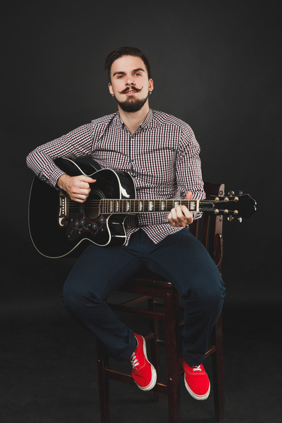 handsome guy with beard holding acoustic guitar - Foto, imagen