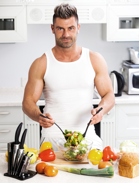 Happy handsome man cooking in kitchen at home. - Fotografie, Obrázek