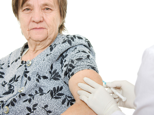 The doctor makes vaccination an old woman. - Foto, Imagen
