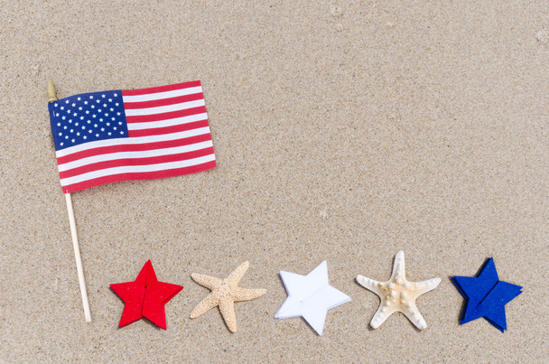 Drapeau américain avec des étoiles de mer sur la plage de sable
 - Photo, image
