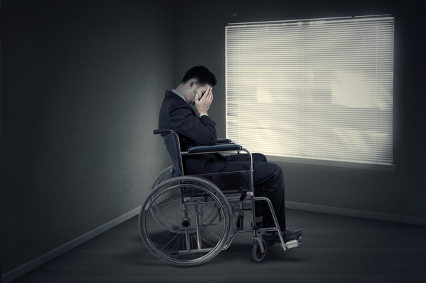 Disabled businessman sitting near the window - Fotó, kép