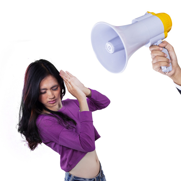 Scared girl scolded with a megaphone - Фото, изображение