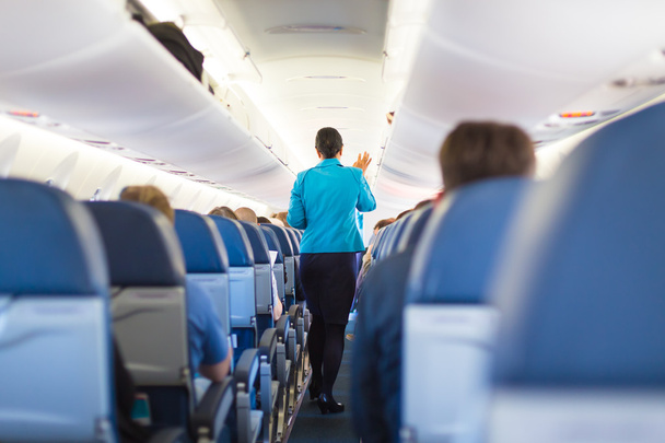 Innenraum eines Flugzeugs mit Passagieren auf Sitzen. - Foto, Bild