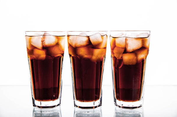 three glasses of cola and ice on a white background. soft drinks - Photo, image