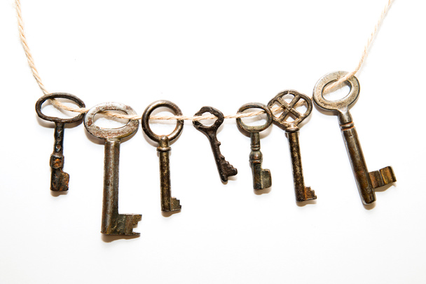 Um monte de chaves vintage das fechaduras em um fundo branco
 - Foto, Imagem