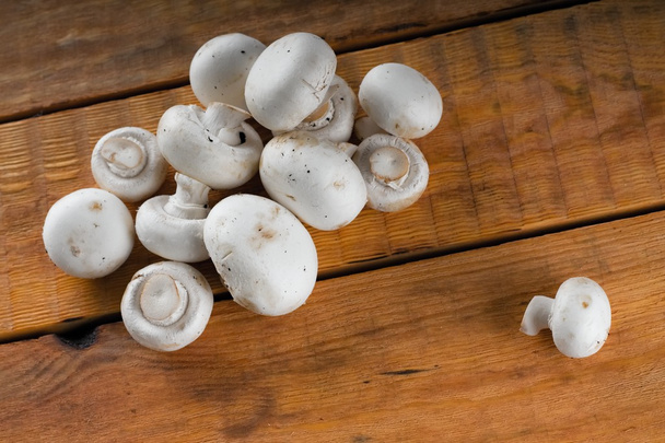 Haufen kleiner frischer Pilze auf Holztisch - Foto, Bild
