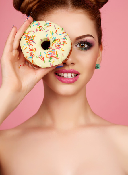 girl with dark hair and bright makeup holding sweet donuts   - Foto, imagen