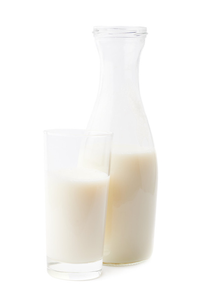 Glass of milk next to bottle - 写真・画像