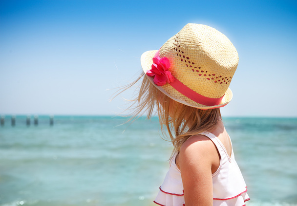 Kis aranyos baba lány visel kalapot a strandon - Fotó, kép