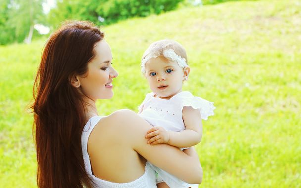 Happy loving mother and baby together outdoors in sunny summer d - Photo, image