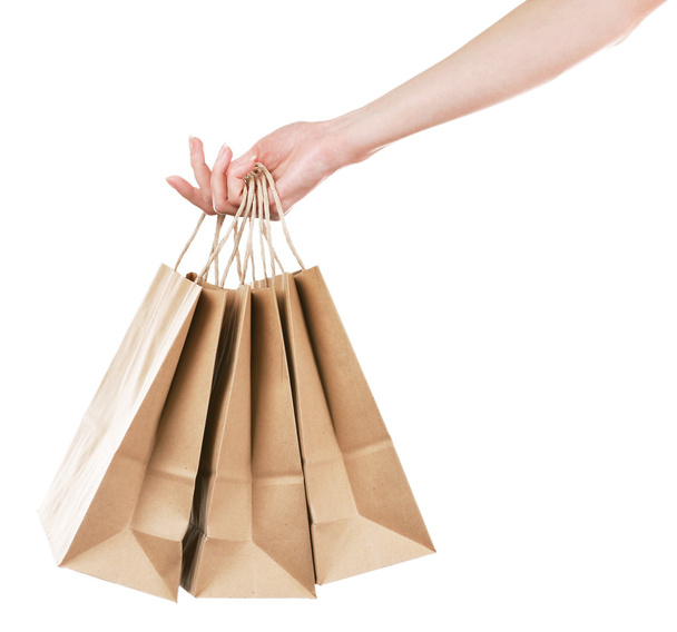 Female hand holding paper shopping bag isolated on white - Foto, immagini
