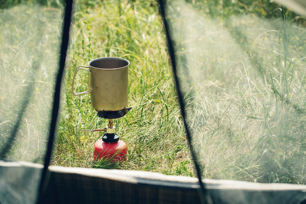 boiling water in mug on portable camping stove - Valokuva, kuva