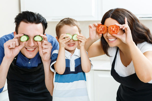 Funny family playing with food in kitchen - Фото, изображение