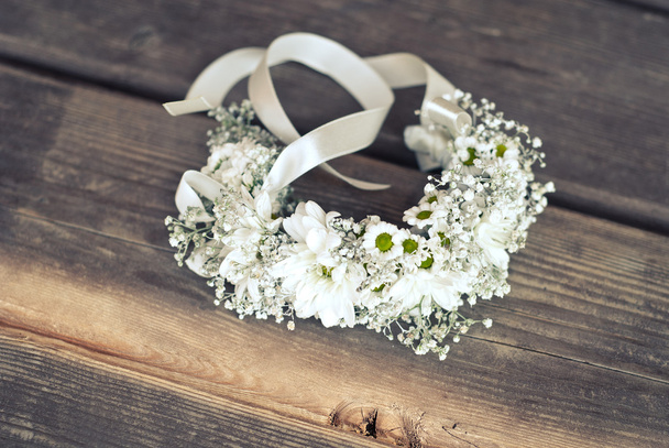 Bracelet avec des fleurs de camomille sur le sol en bois
 - Photo, image