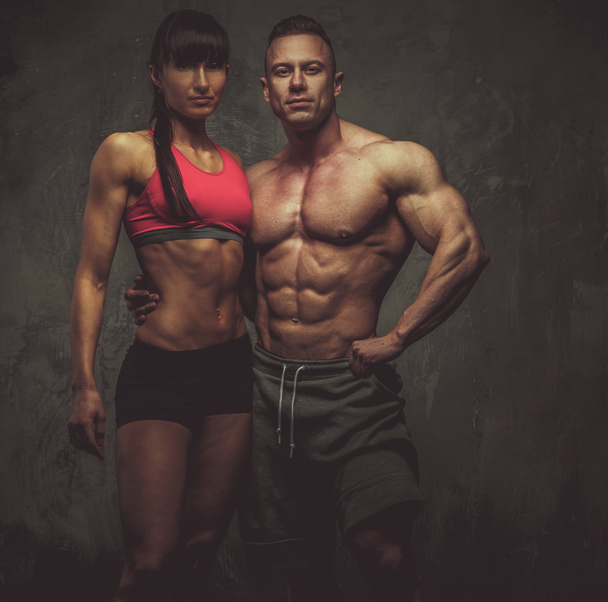 Woman and man bodybuilders posing in studio - Zdjęcie, obraz