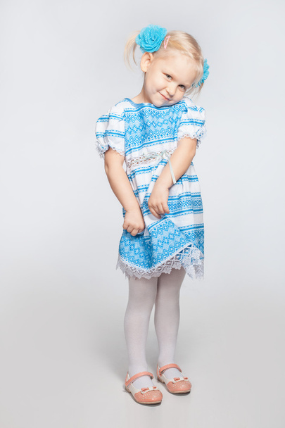 Little girl on a white background shy - Φωτογραφία, εικόνα