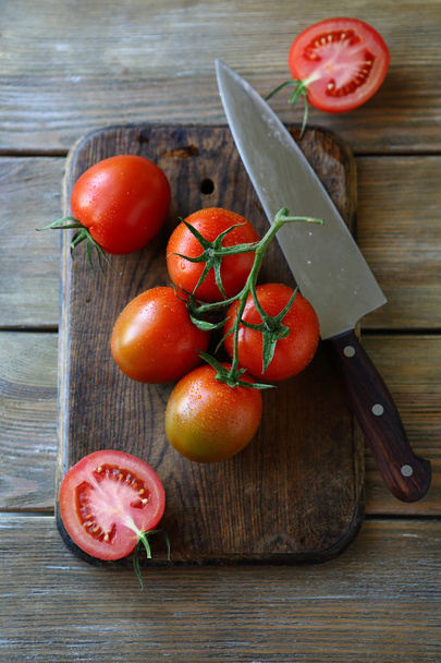 tomatoes on the old cutting board - 写真・画像