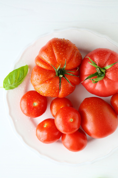  ripe tomato on white plate - Foto, afbeelding