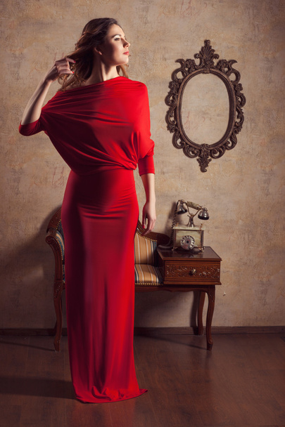 Chica en vestido rojo mirando a un lado
 - Foto, imagen