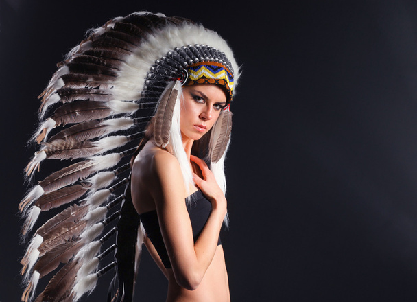 Beautiful woman in native american costume with feathers - Foto, afbeelding