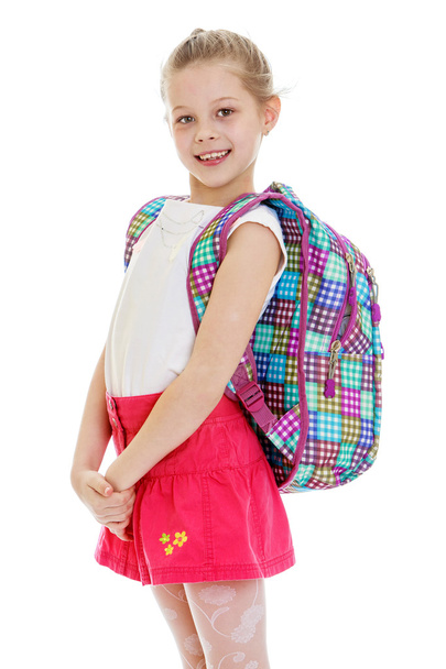 Happy joyful schoolgirl in red skirt and school satchel over his - Fotografie, Obrázek