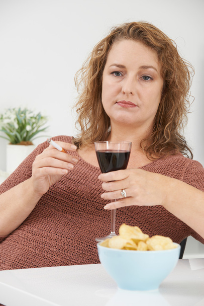 Woman Smoking Cigarette Whilst Drinking Wine And Eating Snacks - Photo, image