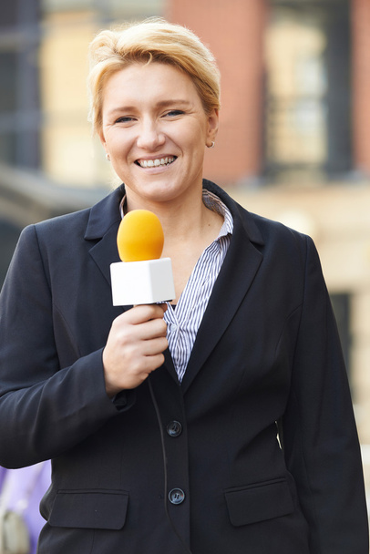 Female Journalist Broadcasting Outside Office Building - Foto, Bild