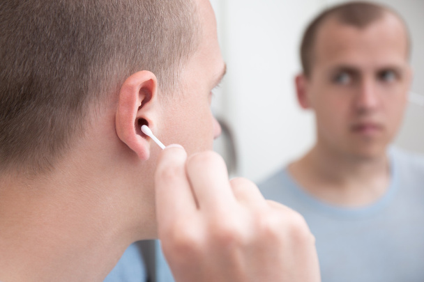 az ember fülébe egy vattacsomót tisztítás  - Fotó, kép