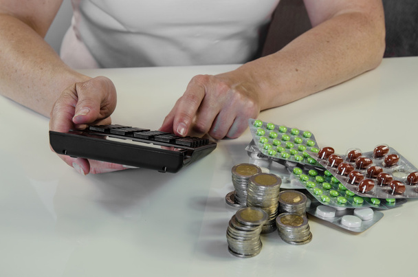 mão com calculadora, dinheiro e pílulas conceito
 - Foto, Imagem