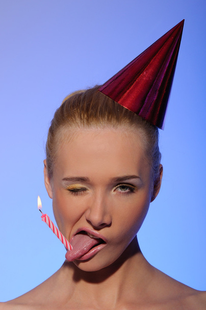 Woman with candle in tongueand festive hat - Φωτογραφία, εικόνα