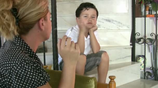 Little boy looking at his mother while smoking cigarette - Imágenes, Vídeo