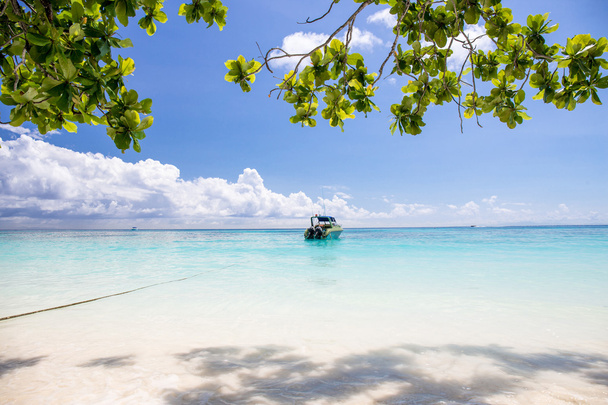 Belle mer cristalline et plage de sable blanc avec bateau
 - Photo, image