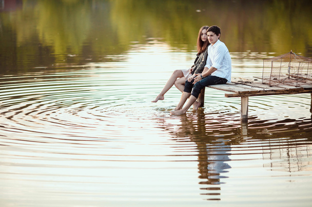 Happy romantic couple rowing a small boat on lake - Valokuva, kuva