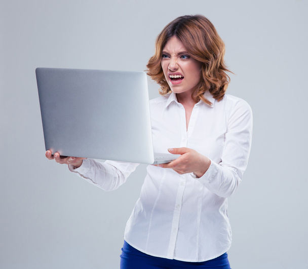 Businesswoman with disgusted emotion holding laptop - Valokuva, kuva