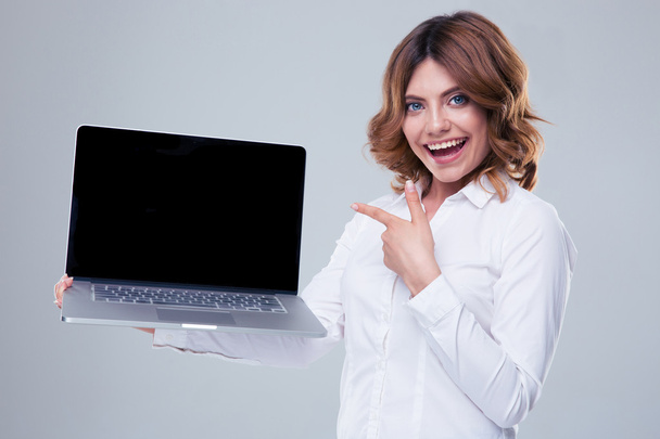 Happy businesswoman pointing finger on laptop screen - Foto, afbeelding