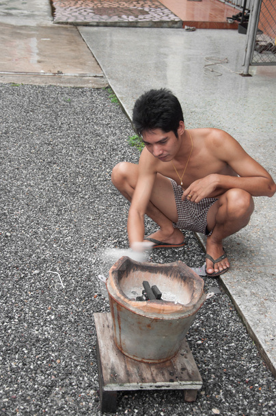 asiatique homme lumière charbon poêle
 - Photo, image