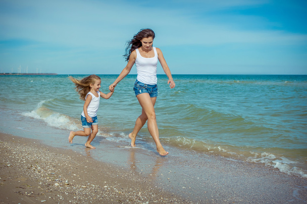 Feliz hermosa madre e hija disfrutando del tiempo de playa
  - Foto, Imagen