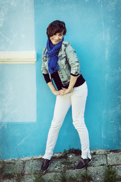 Beautiful caucasian woman posing in front of the blue wall - Foto, Bild