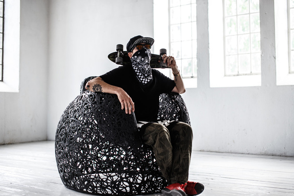 Man in gangster masker met skateboard. - Foto, afbeelding