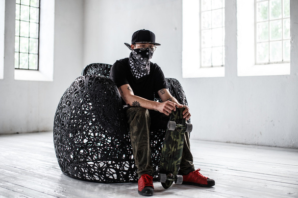 Man in gangster mask with skateboard. - Foto, Bild