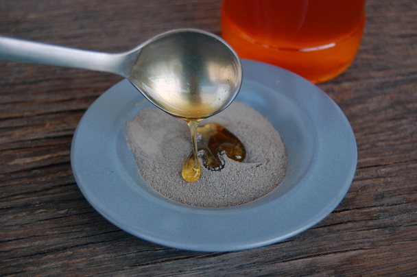 Argila cosmética em uma tigela de cerâmica com mel
. - Foto, Imagem
