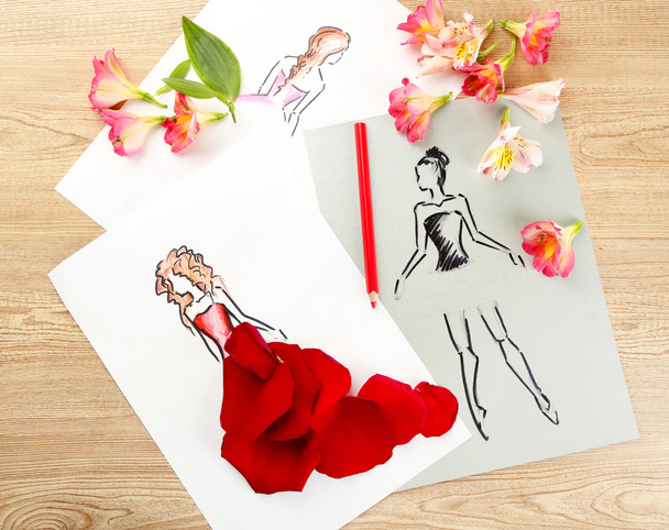 Pictures with flower petals and pencils on wooden table - Foto, afbeelding