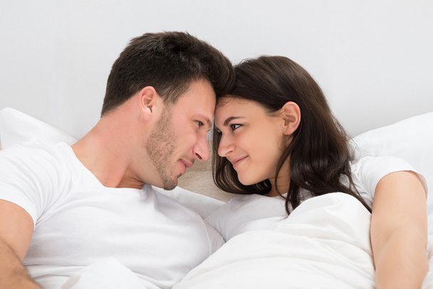 ロマンチックなカップルはベッドの上 - 写真・画像