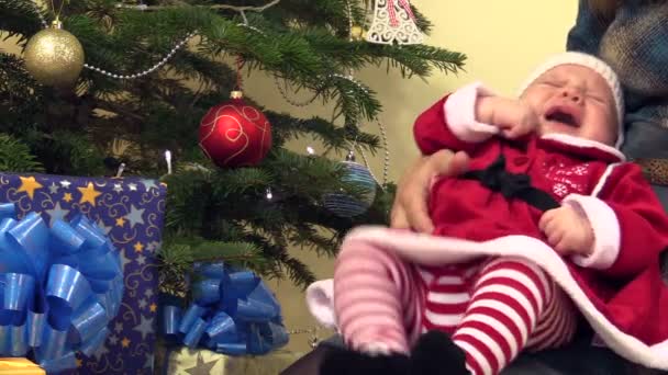 Schattige pasgeboren baby in kerstfeest jurk in slaap vallen op moeder handen - Video