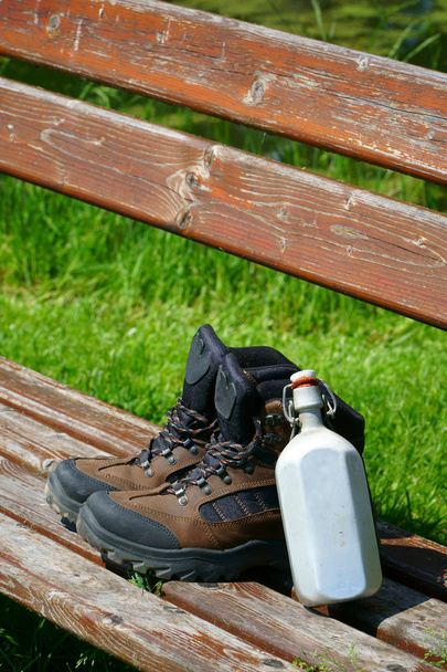 Hiking boots on a seat bench - Fotó, kép