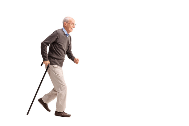 Senior man walking fast with a cane - Фото, изображение