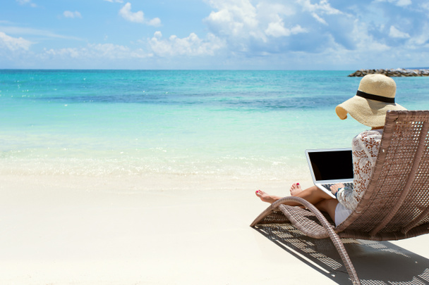 Business woman using laptop computer on the beach - Photo, Image
