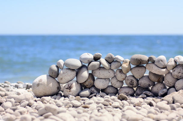 Kövek a tengerparton egy falba halmozott - Fotó, kép