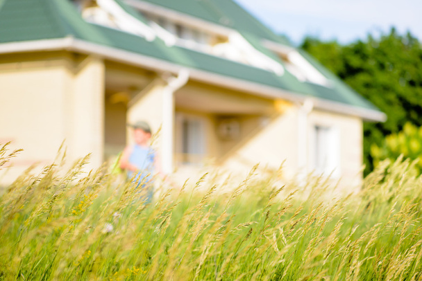 Garçon expoloring avec Bug Net dans l'herbe longue par la maison
 - Photo, image