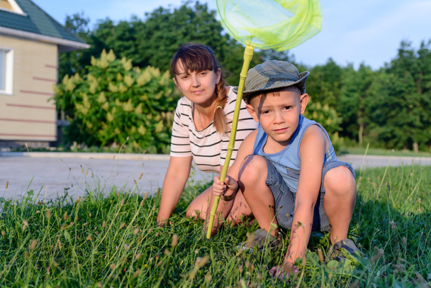 Мати і син з Bug Net Досліджуючи на газоні
 - Фото, зображення